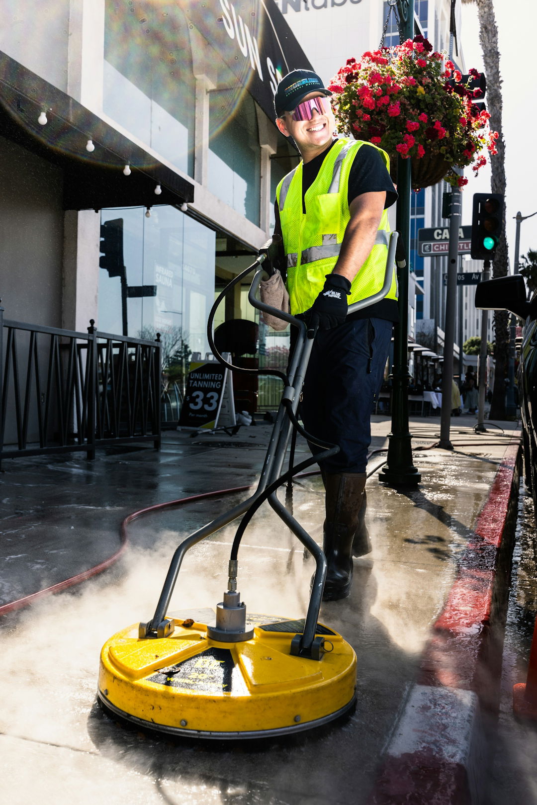 a man in a yellow vest is cleaning the street